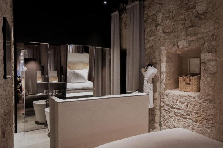 Baño de suite de lujo con bañera exenta y paredes de piedra natural en Nobis Hotel Palma