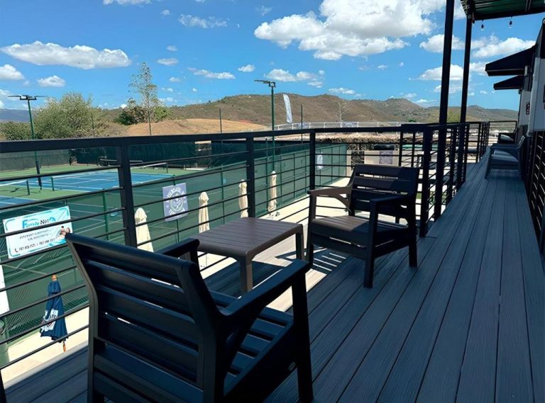 Terraza con sillas y mesa con vistas a las pistas de tenis de Hacienda del Sur y montañas al fondo