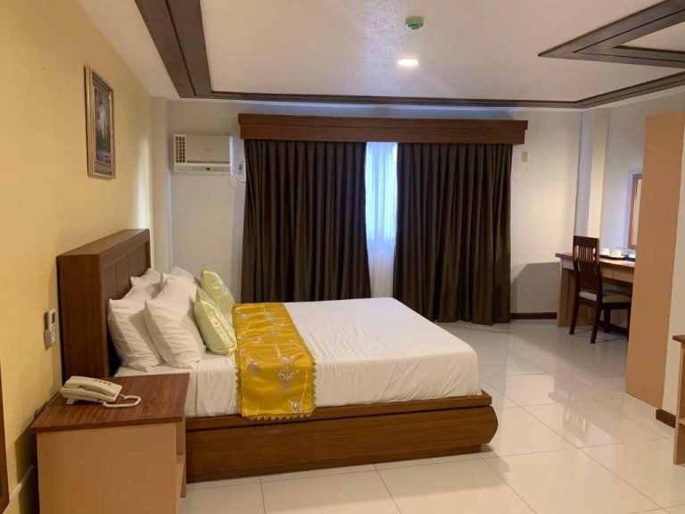 Habitación doble con cama king size y decoración elegante en Surigao Royal Regency Suites