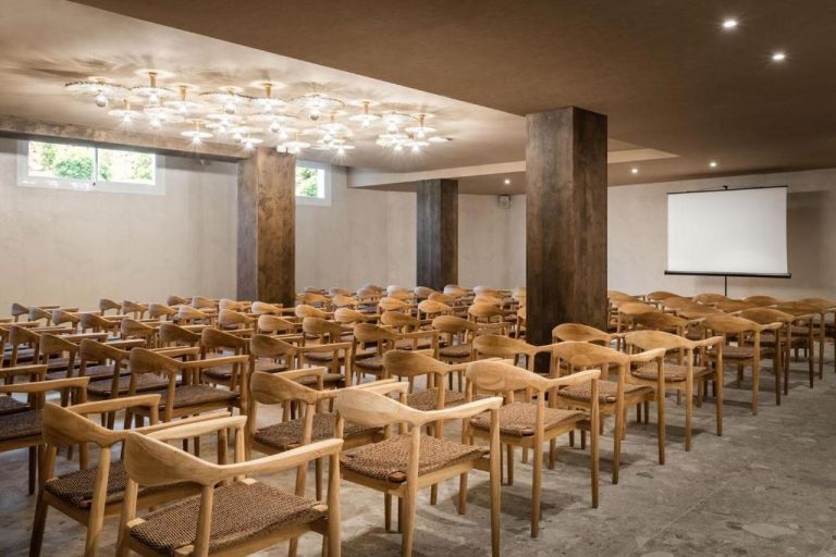 Sala de reuniones y conferencias con sillas de madera y pantalla de proyección en Lago Resort Menorca