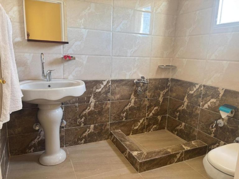 Baño privado con ducha y aguas termales en Beir El Gabal Hotel, con azulejos de mármol oscuro