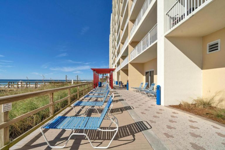 Terraza con tumbonas azules y acceso directo a la playa en Panama City Beach, Florida