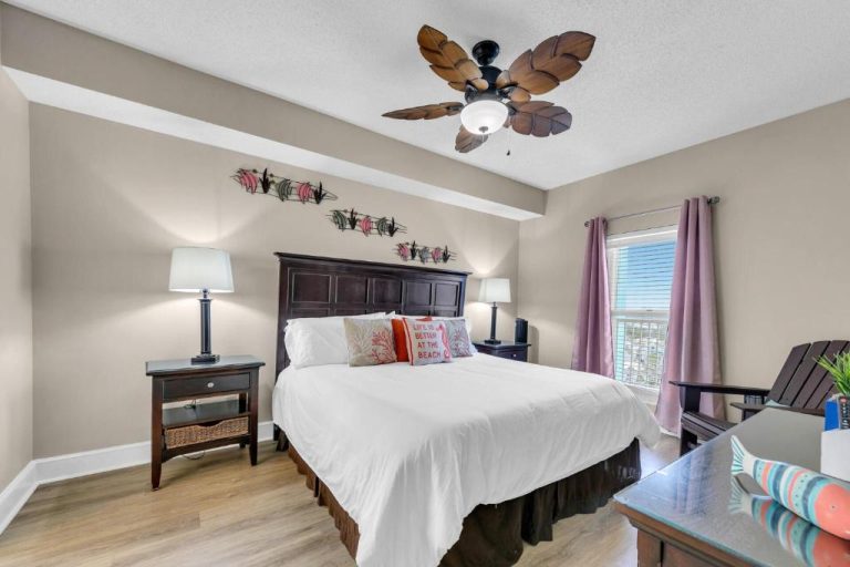 Habitación king size con ventilador de techo tropical y vistas al mar en Panama City Beach, Florida
