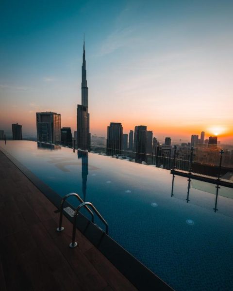 Piscina infinita del Paramount Hotel Midtown con vistas al Burj Khalifa al atardecer en Dubái
