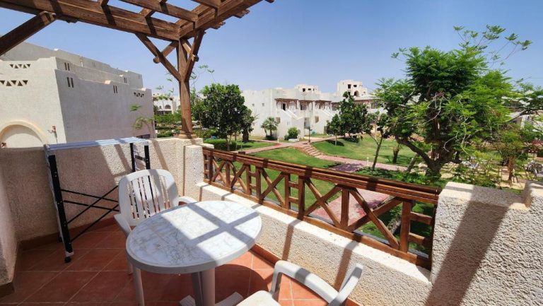 Terraza con mesa y sillas del Hotel Suite In Jazz Sharm Dreams con vistas al jardín y villas