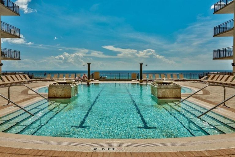 Piscina exterior con vistas al mar en Origin 1227 Beachy Dreams, rodeada de tumbonas y jacuzzis