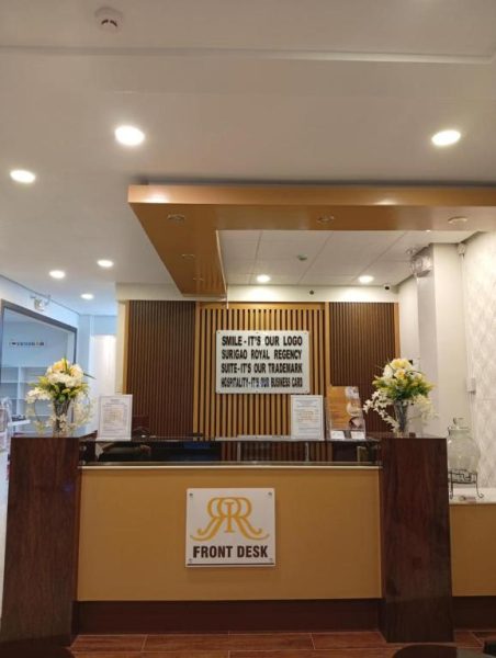 Recepción principal con mostrador de Front Desk del Surigao Royal Regency Suites con decoración floral