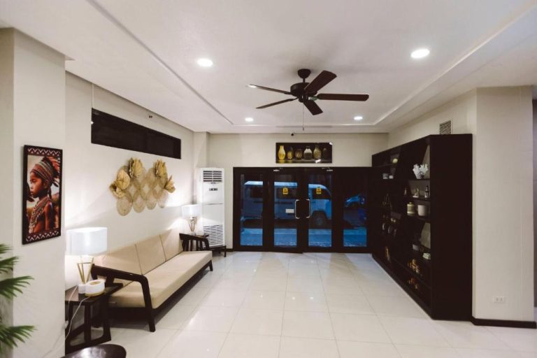 Lobby moderno con sofá, ventilador de techo y entrada principal del Surigao Royal Regency Suites