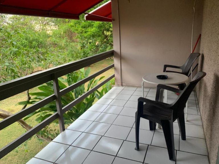 Terraza con sillas y mesa del Garden Beach Resort con vistas al jardín tropical y vegetación