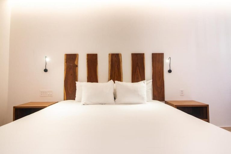Habitación doble con elegante cabecero de madera natural y ropa de cama blanca en Hotel B10 Distinctive Hotel