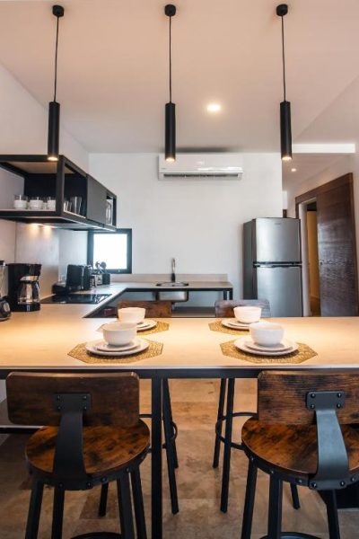 Cocina moderna con barra de desayuno y taburetes de madera en el Hotel B10 Distinctive Hotel