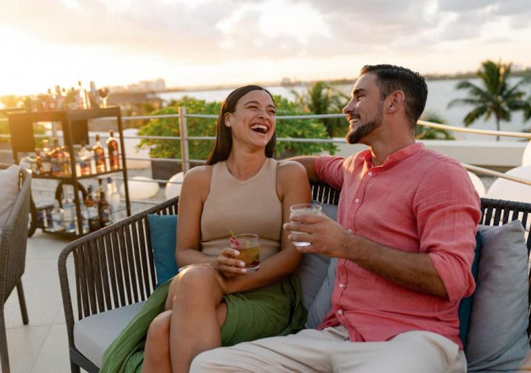 Pareja disfrutando de cocktails en la terraza del Grand Park Royal Cancún con vistas al atardecer