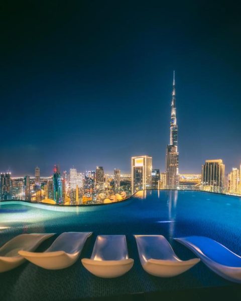 Piscina infinita del Paramount Hotel Midtown con vistas nocturnas al Burj Khalifa y skyline de Dubái
