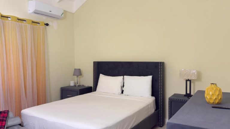 Habitación doble con cama grande y cabecero negro en Jamnick Vacation Rentals, Jamaica
