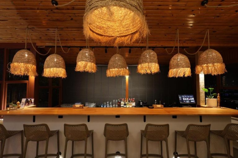 Bar con encimera de madera y lámparas de ratán en Casa Vagabundo Adults Only