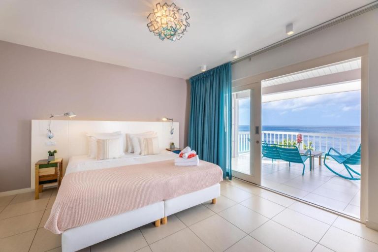 Habitación de lujo con cama doble y terraza con vistas al mar en Coral Estate Luxury Resort