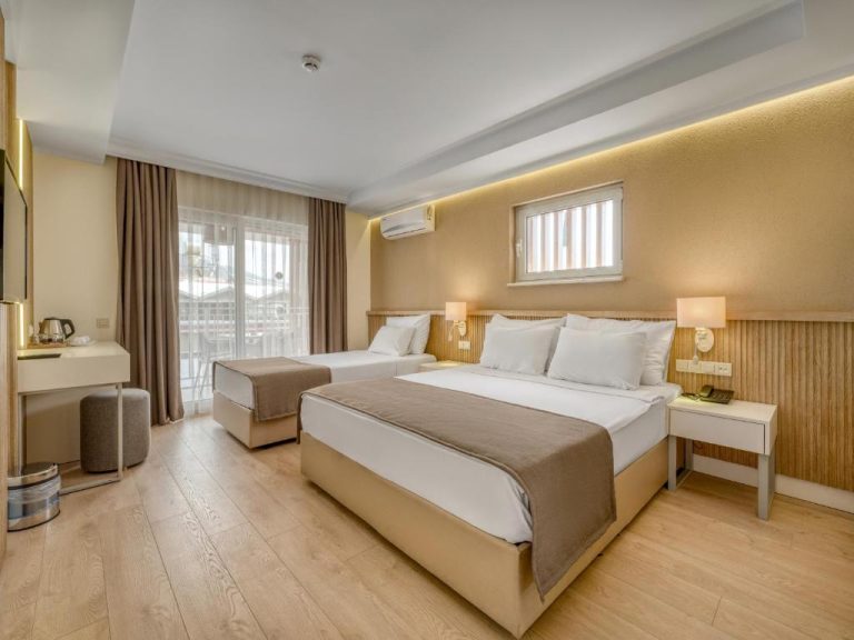 Habitación triple moderna con dos camas y suelos de madera clara en Park Hotel