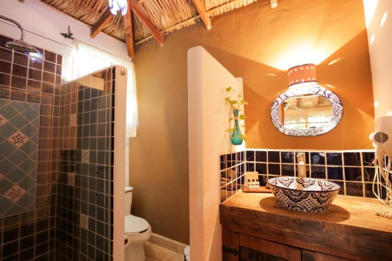 Baño rústico con lavabo de talavera y ducha de azulejos en The Bungalows Hotel