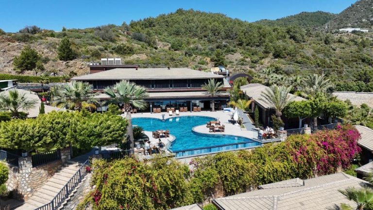Piscina exterior con vistas a la montaña y jardines tropicales del Porto Amore Club Hotel