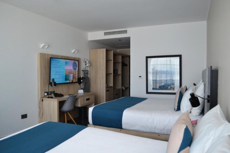Habitación twin con dos camas, escritorio de trabajo y televisión del be.HOTEL Malta
