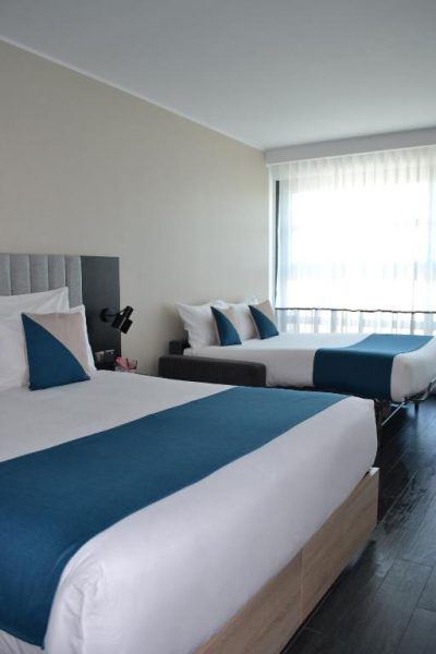 Habitación doble con dos camas y decoración en azul y blanco en be.HOTEL
