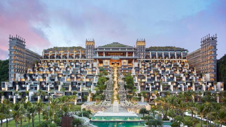 Vista exterior del The Apurva Kempinski Bali con arquitectura escalonada, jardines tropicales y piscina al atardecer