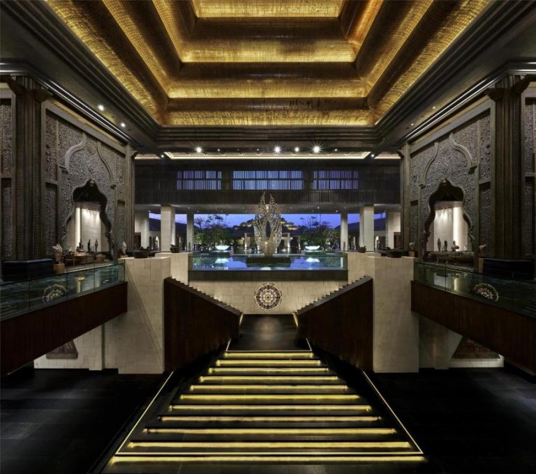 Lujoso lobby con escalinata iluminada y fuente central en The Apurva Kempinski Bali