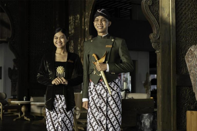 Personal del Apurva Kempinski Bali en uniforme tradicional javanés con batik y keris ceremonial