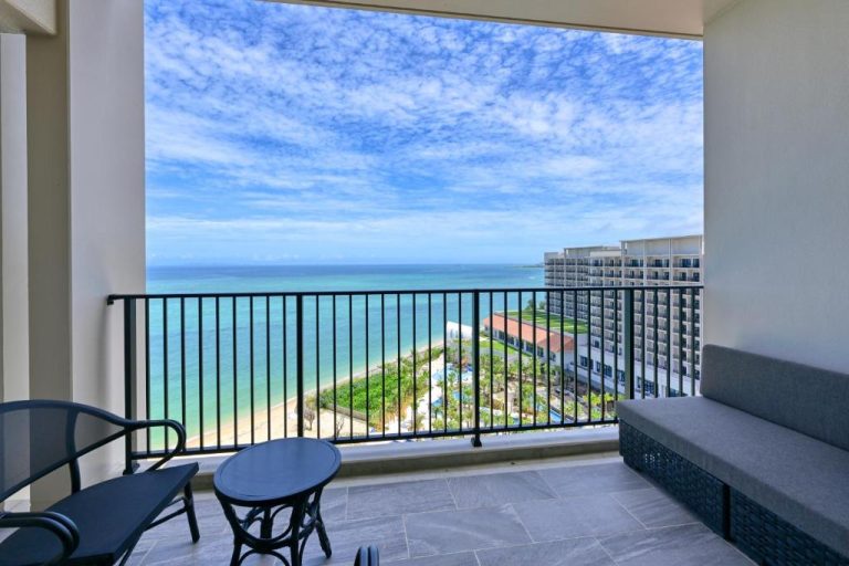 Balcón privado con vistas al mar turquesa y playa del Ryukyu Hotel & Resort Nashiro Beach en Okinawa