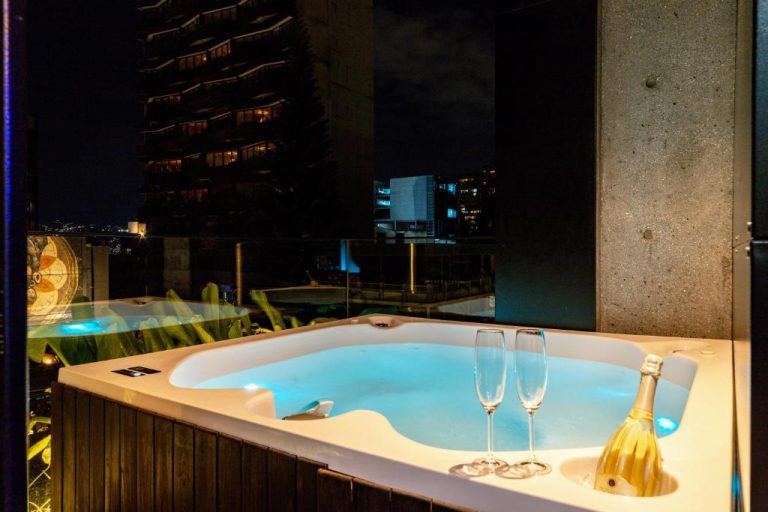 Jacuzzi privado en terraza con vista nocturna a la ciudad en Primavera Luxury Apartments Medellín