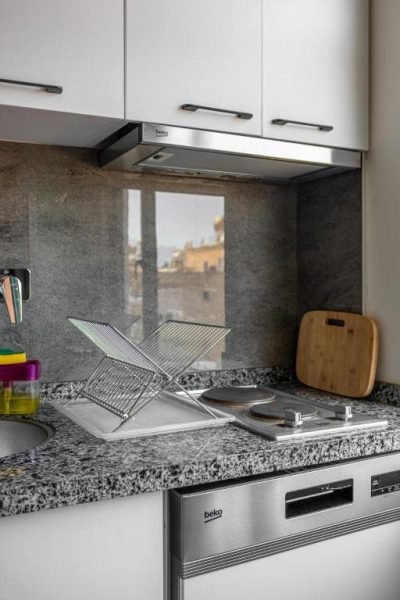 Cocina equipada con vitrocerámica, campana extractora y encimera de granito en Pasham Residence