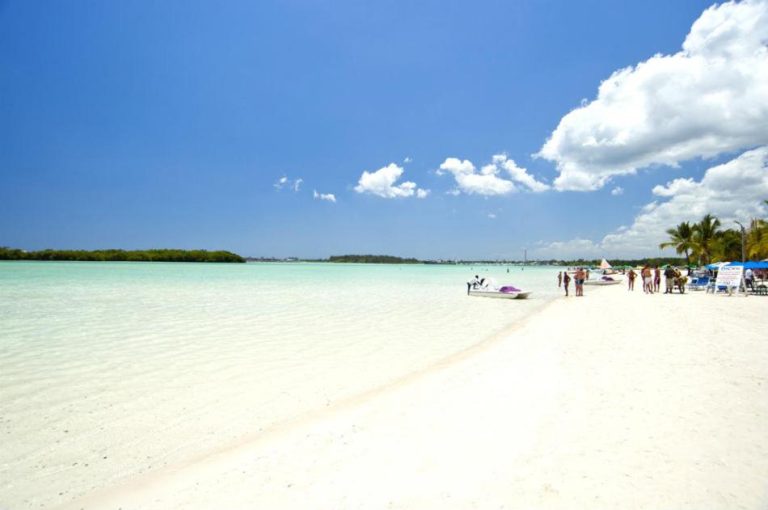 Playa de aguas turquesas y arena blanca del Hotel Hannabi con visitantes disfrutando del sol