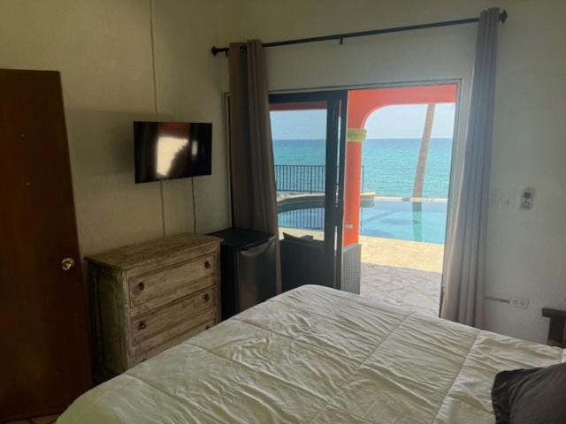 Habitación con cama doble y terraza con vista al mar en Hotel Sauza, con TV y cómoda de madera