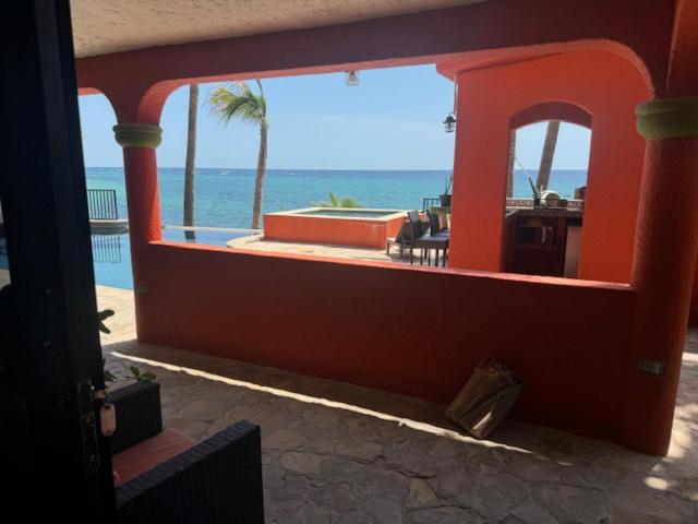 Terraza con arcos rojos y vista al mar turquesa en Hotel Sauza con jacuzzi exterior y palmeras