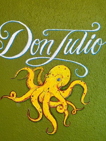 Mural artístico con pulpo dorado y letrero Don Julio en la fachada decorativa del Hotel Sauza