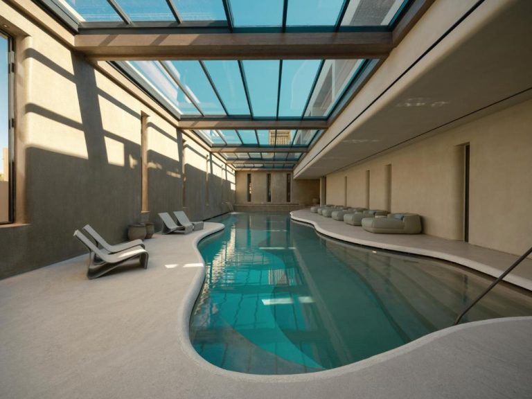 Piscina interior cubierta con techo de cristal y tumbonas del Minos Palace Resort Adults Only
