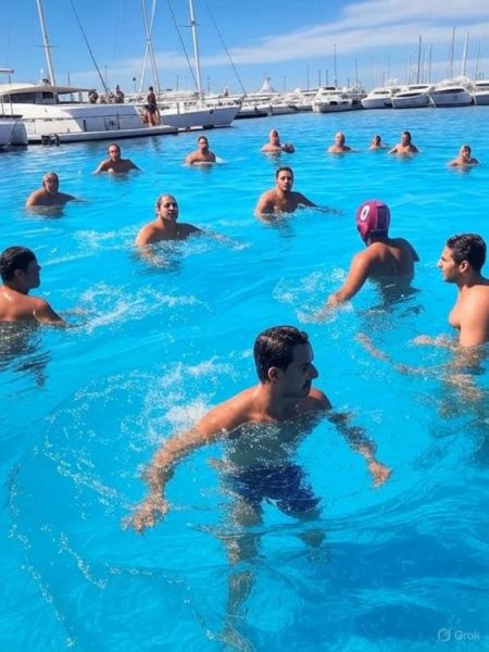 Grupo de personas practicando polo acuático en la piscina exterior del Hotel Golf Marina con vistas al puerto deportivo