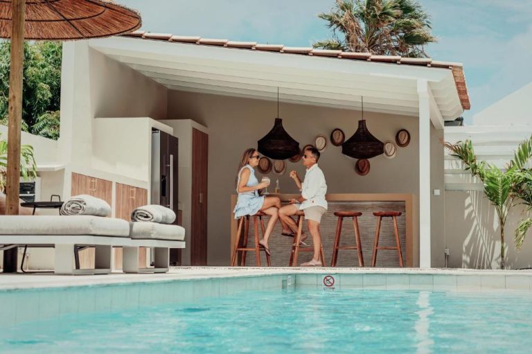 Pareja disfrutando de cócteles en el bar junto a la piscina exterior del Yucca Mini Boutique Hotel Adults Only