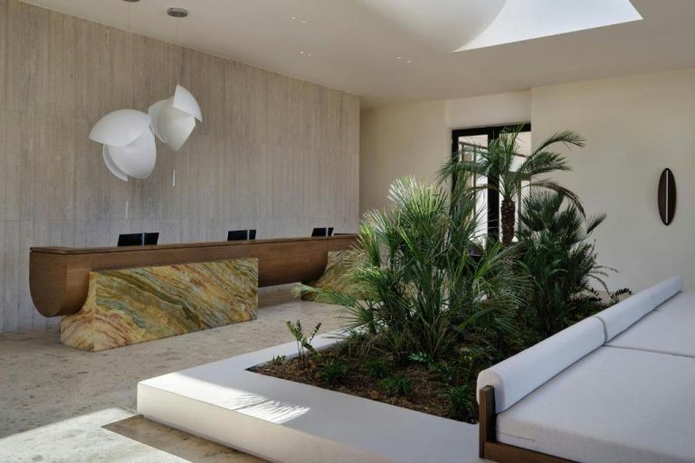 Recepción con jardín tropical interior y mostrador de mármol en JW Marriott Crete Resort & Spa