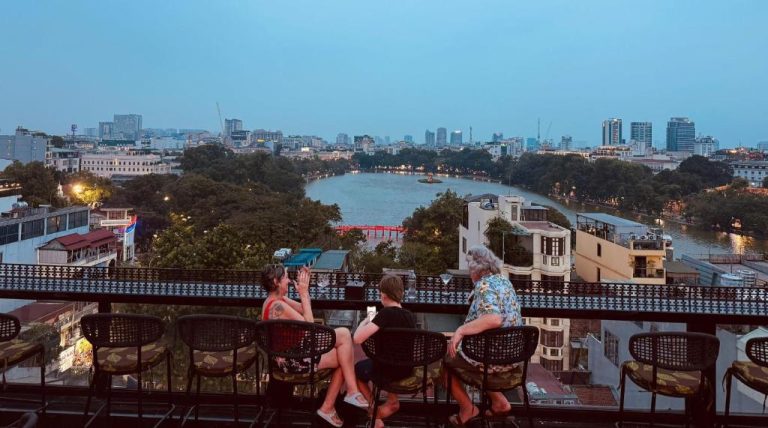 Terraza rooftop bar del Lucien Hanoi Lakeside Hotel con vistas panorámicas al lago Hoan Kiem al atardecer