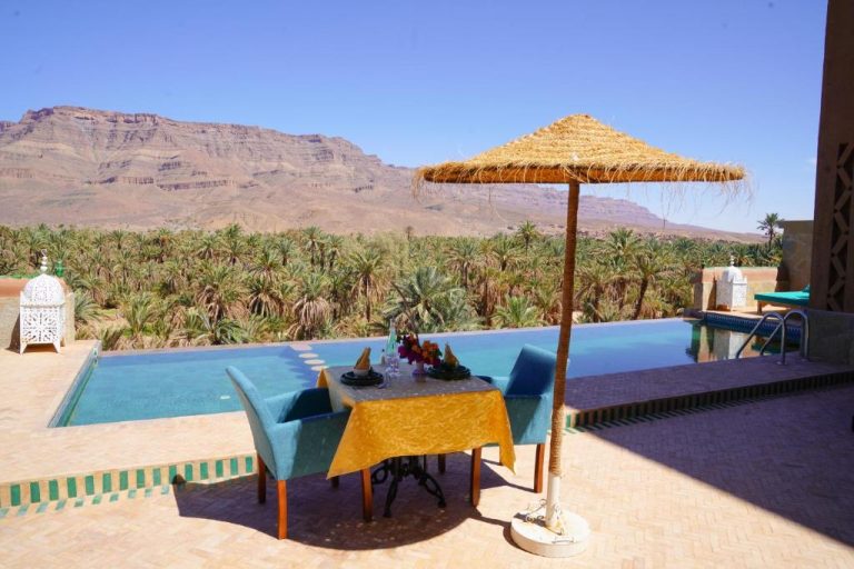 Piscina infinita con vistas al oasis y montañas del desierto en Kasbah Hnini Marruecos