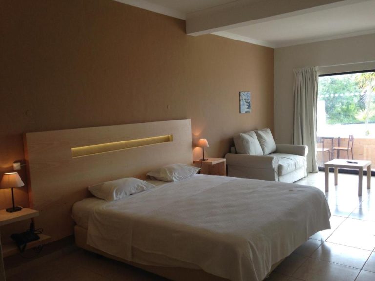 Habitación doble con cama king size, sofá y terraza con vistas al jardín en Hotel Vilamar