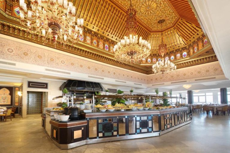 Lujoso restaurante buffet del Hotel Sol Azur con techo dorado decorado y grandes lámparas de araña
