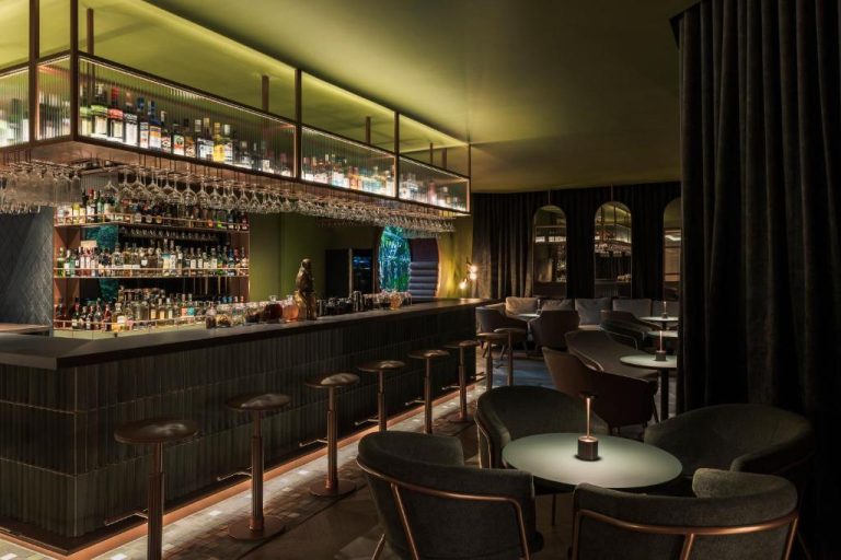 Bar de coctelería con iluminación tenue y ambiente elegante en el Hotel Poblado Plaza