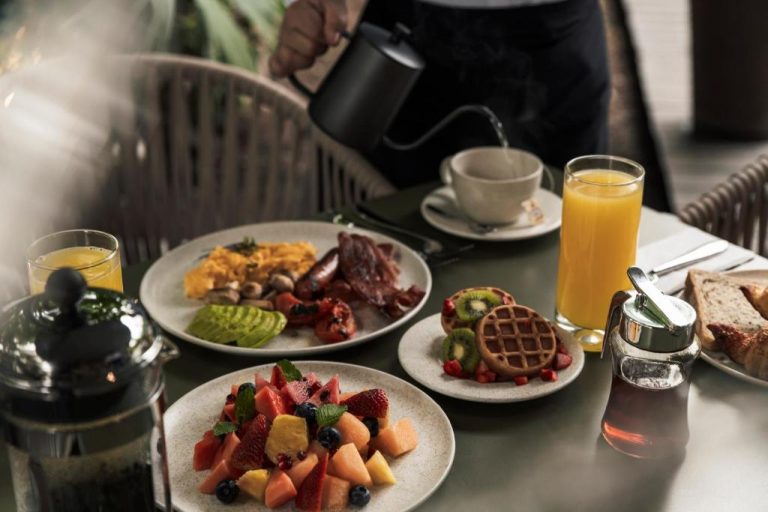 Desayuno completo con frutas, waffles, huevos y zumo de naranja en el Hotel Poblado Plaza