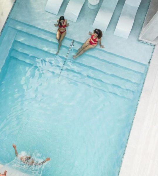 Piscina interior con toboganes y bañistas en el Hotel Nautilus by La Jamaca en La Parguera