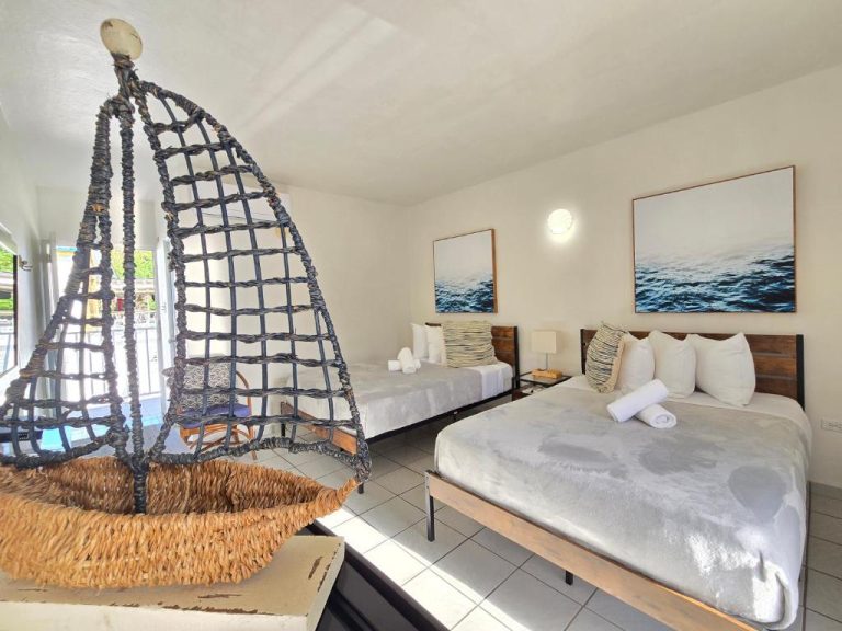 Habitación doble con decoración náutica y silla colgante de mimbre en Nautilus by La Jamaca Hotels La Parguera