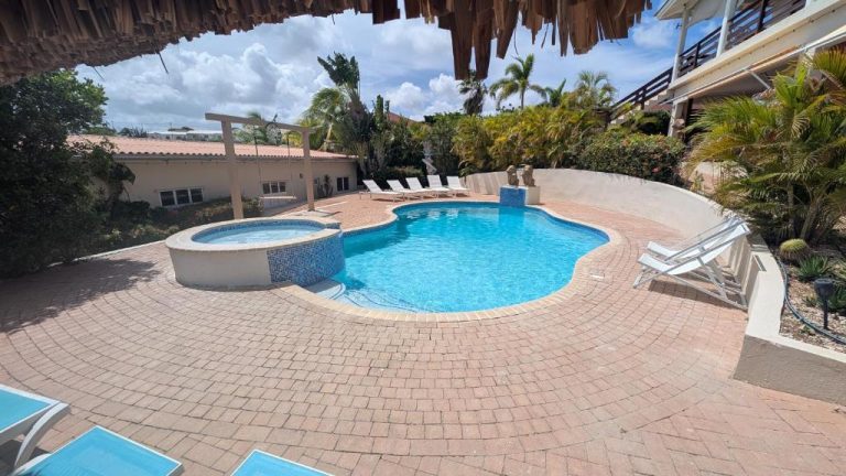 Piscina exterior con jacuzzi y tumbonas en Home Sweet Home Jan Thiel Curaçao con jardín tropical