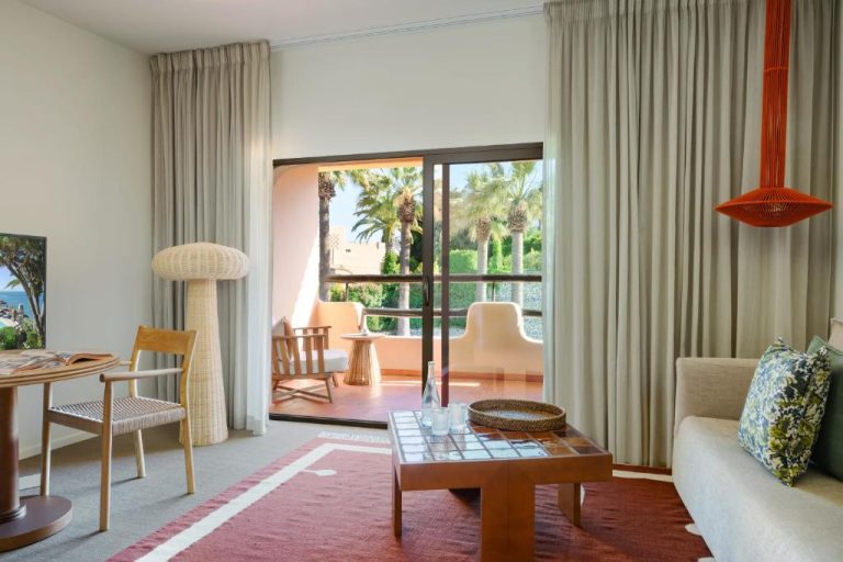Salón luminoso con terraza y vistas a palmeras en el Vilalara Grand Hotel Algarve