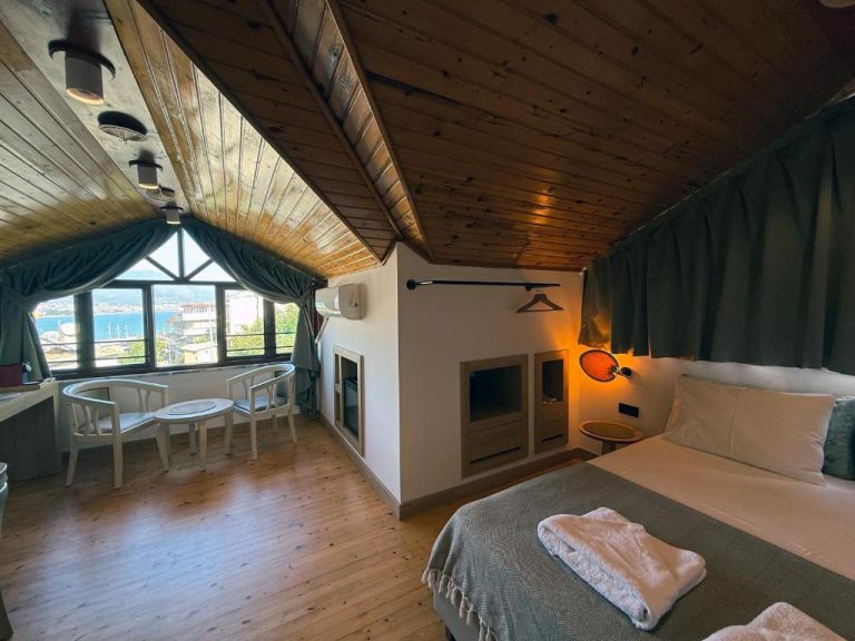 Habitación abuhardillada con techo de madera y vistas al mar en Casa Vagabundo Adults Only